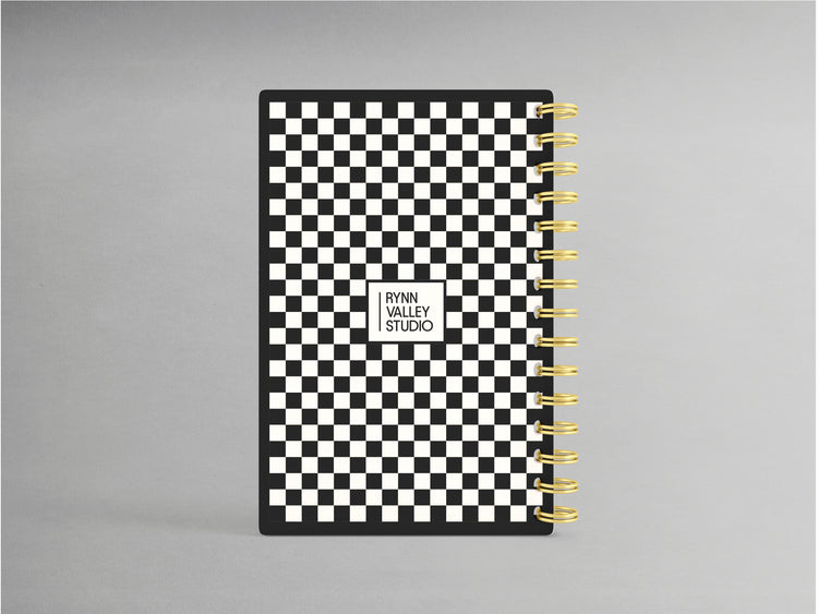 Enhance your note-taking experience with this sophisticated A5-sized hardcover spiral bound notebook, showcasing an elegant black and white checkerprint design. Accented with a luxurious gold spiral, its interior boasts blank pages, offering versatility for sketches, notes, or creative projects.