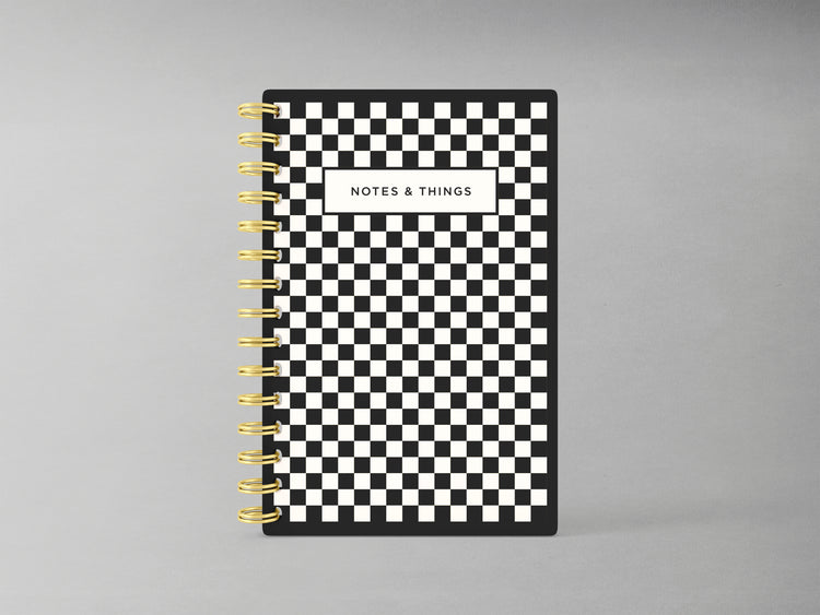 Enhance your note-taking experience with this sophisticated A5-sized hardcover spiral bound notebook, showcasing an elegant black and white checkerprint design. Accented with a luxurious gold spiral, its interior boasts blank pages, offering versatility for sketches, notes, or creative projects.