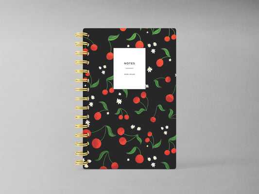 Embrace sophistication with this cherry-themed A5-sized hardcover spiral bound notebook, set against a sleek black background. Its design highlights a rich cherry motif, accented by a sturdy black spiral binding. Inside, enjoy the versatility of blank pages, ideal for jotting down notes, sketches, or creative inspirations with a touch of elegance.