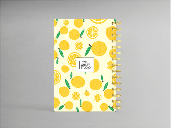 Discover a refreshing addition to your stationery collection with this A5-sized hardcover spiral bound notebook, featuring a delightful lemon design against a light yellow background. Enhanced by a sturdy spiral in complementary gold, its interior offers blank pages ready for your thoughts, sketches, or plans, combining style and functionality in one chic package.