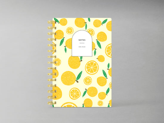 Discover a refreshing addition to your stationery collection with this A5-sized hardcover spiral bound notebook, featuring a delightful lemon design against a light yellow background. Enhanced by a sturdy spiral in complementary gold, its interior offers blank pages ready for your thoughts, sketches, or plans, combining style and functionality in one chic package.